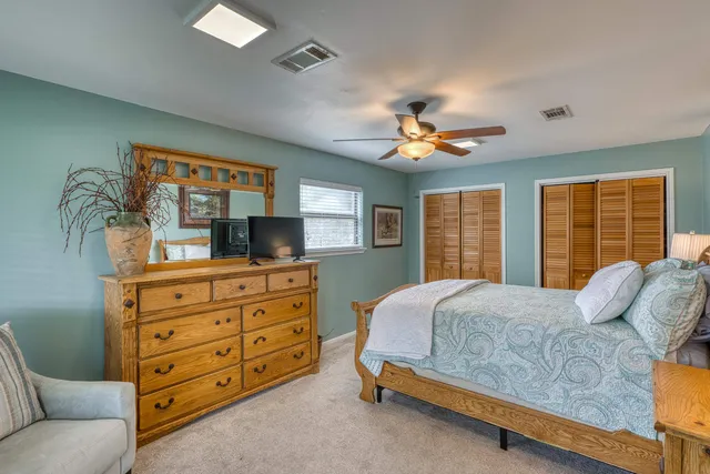 a bedroom with a bed a window and a flat screen television