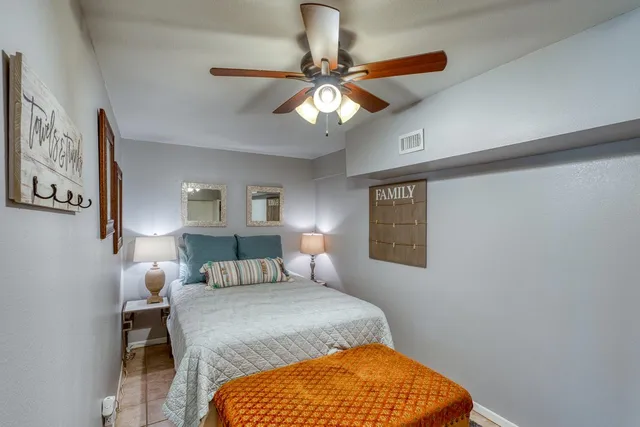 a bedroom with a bed and lamp on dresser