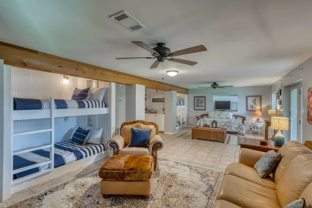 a living room with furniture a ceiling fan and a rug