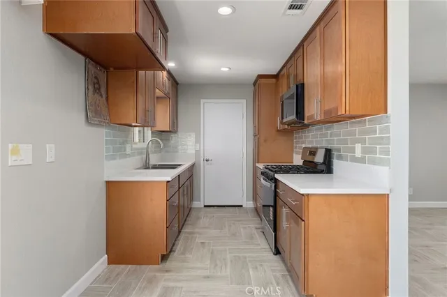 a kitchen with stainless steel appliances granite countertop a sink stove and refrigerator