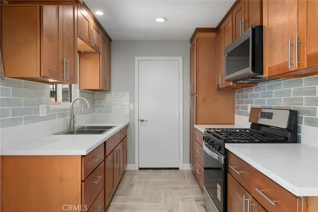 a kitchen with stainless steel appliances granite countertop a sink stove and microwave