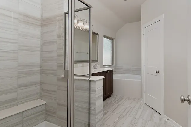 a bathroom with a double vanity sink a tub and a mirror