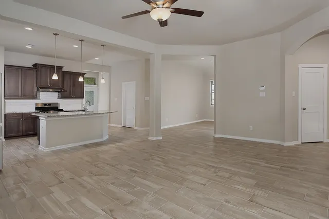 a kitchen with stainless steel appliances granite countertop a refrigerator a sink a stove a microwave and wooden cabinets