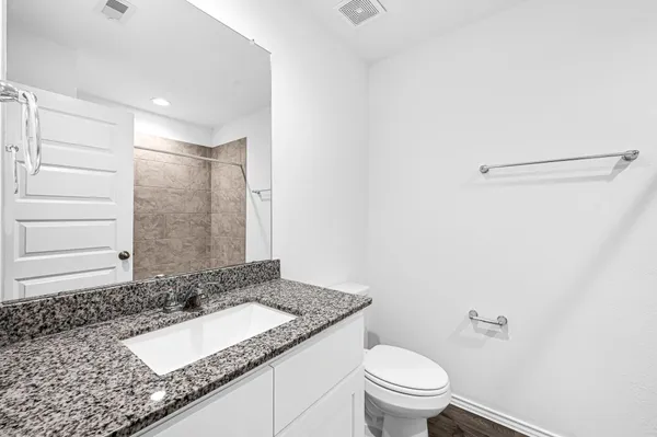 a bathroom with a granite countertop sink and a mirror