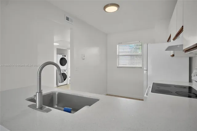 a close view of a sink a faucet and a stove in a room