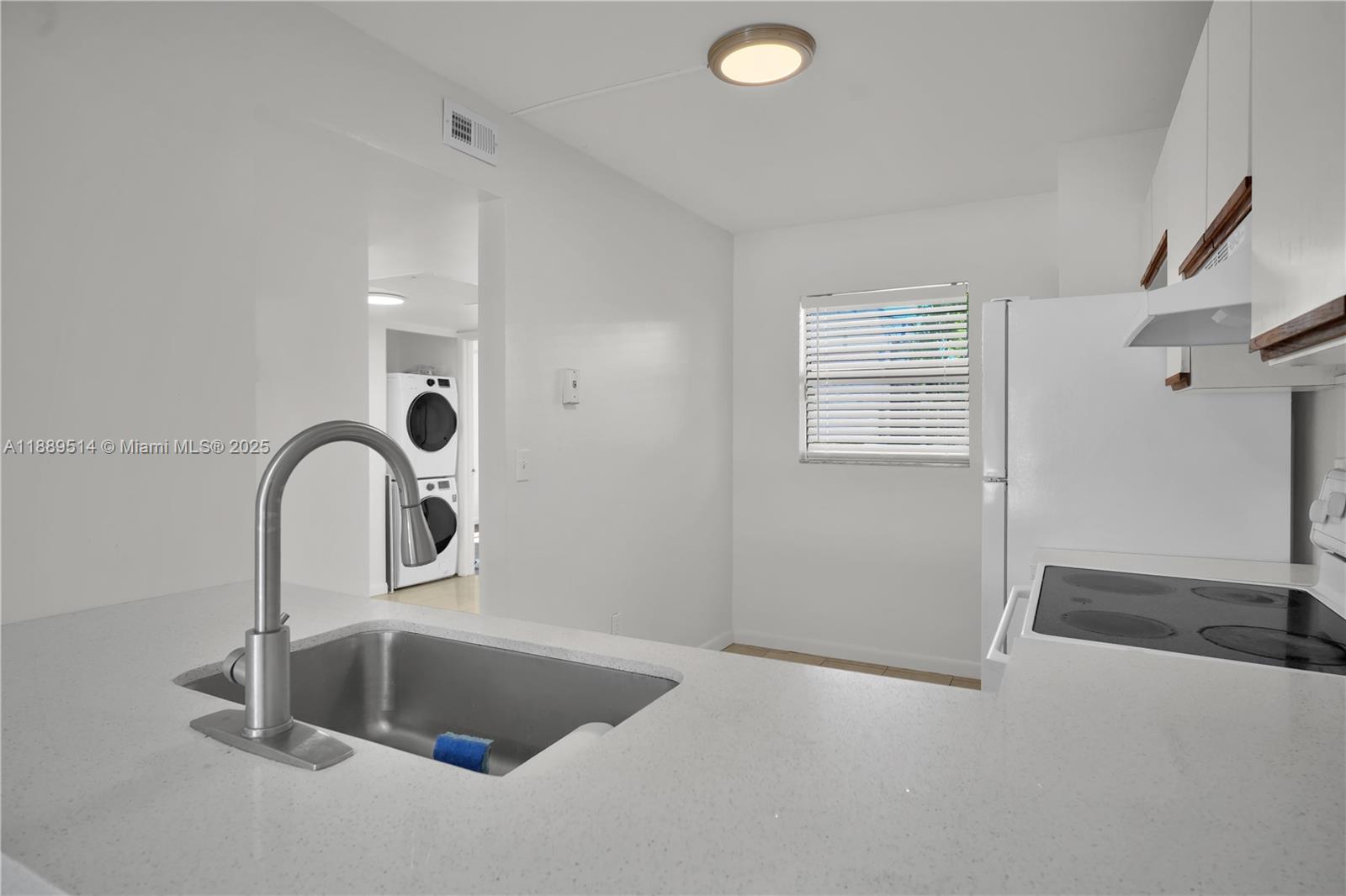 860 Northeast 207th Terrace, Unit 8106 Miami, FL 33179 - Photo 17 of 24 a close view of a sink a faucet and a stove in a room
