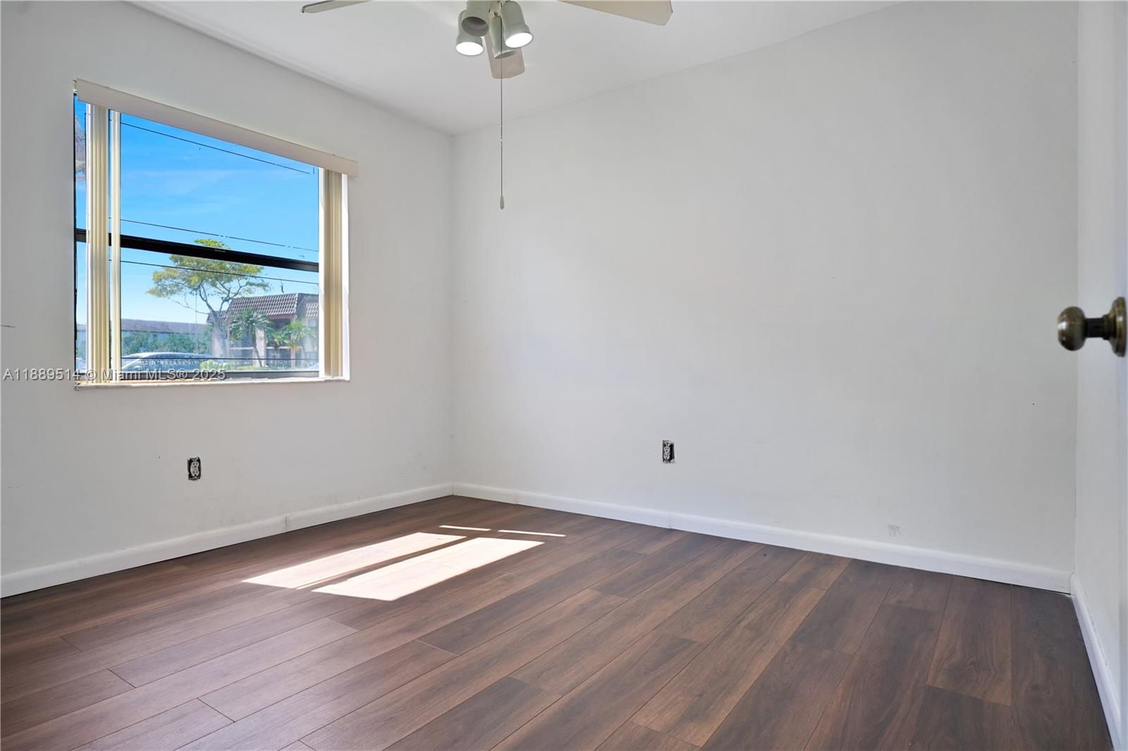 860 Northeast 207th Terrace, Unit 8106 Miami, FL 33179 - Photo 22 of 24 an empty room with wooden floor and windows