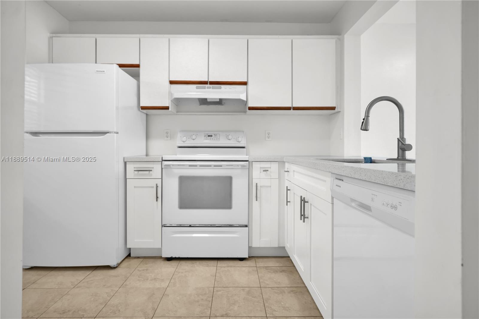 860 Northeast 207th Terrace, Unit 8106 Miami, FL 33179 - Photo 7 of 24 a kitchen with white cabinets and white appliances