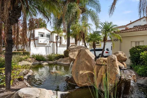 a view of a swimming pool with a lawn chairs under an umbrella