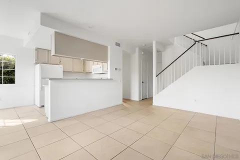 a view of a kitchen with wooden cabinets and staircase