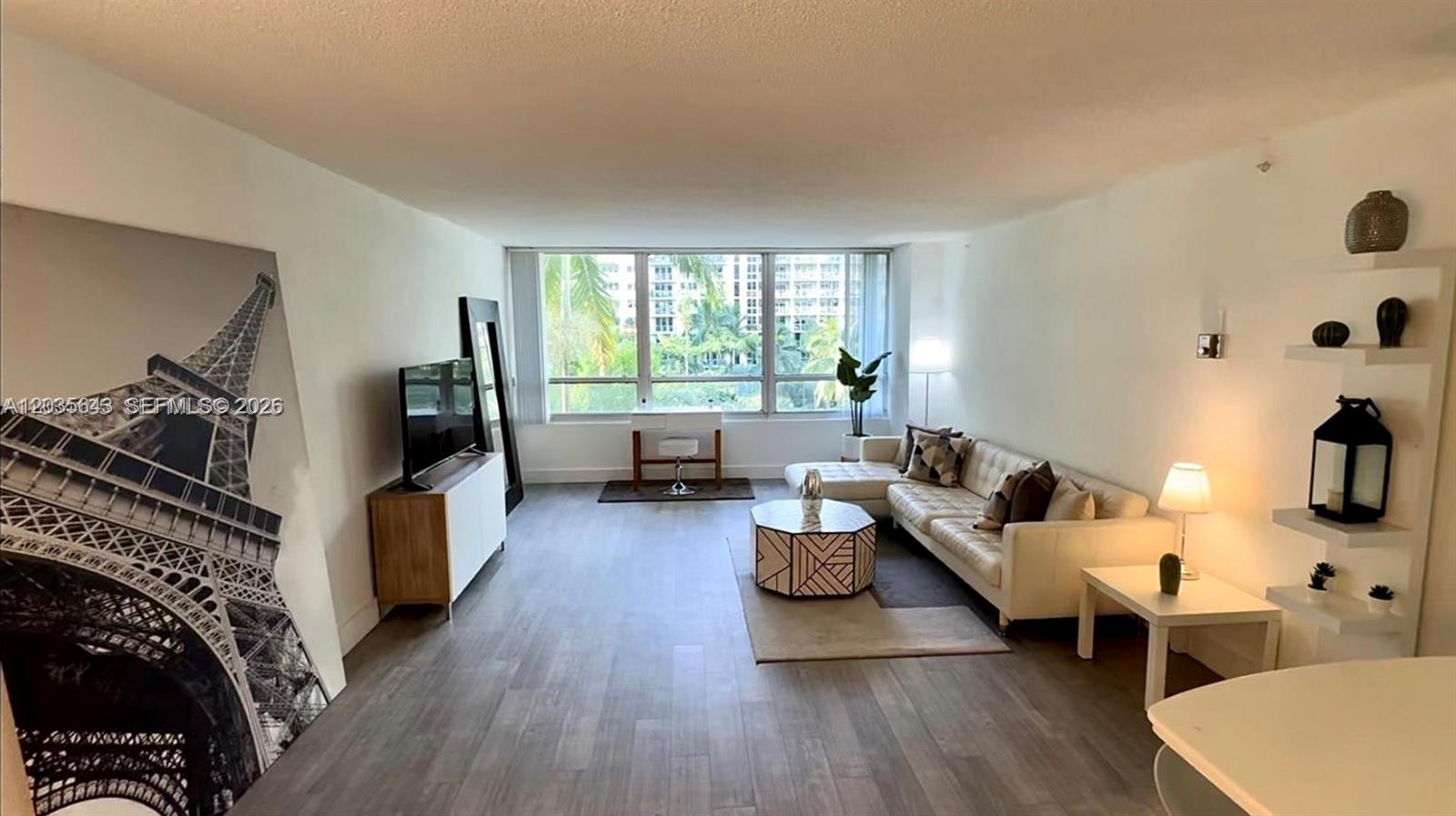 1500 Bay Road, Unit 450S Miami Beach, FL 33139 - Photo 4 of 22 a living room with furniture and a flat screen tv