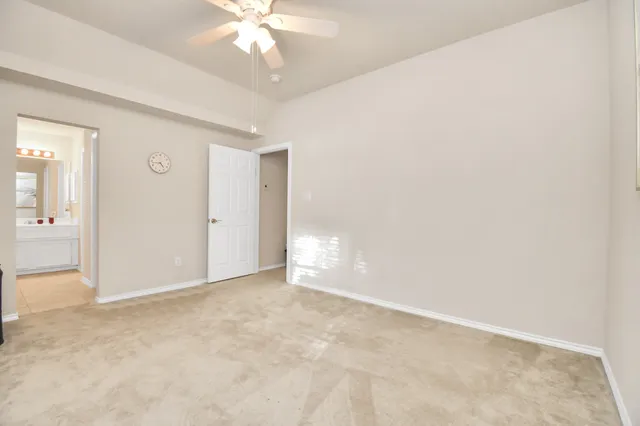 a view of an empty room with a chandelier fan