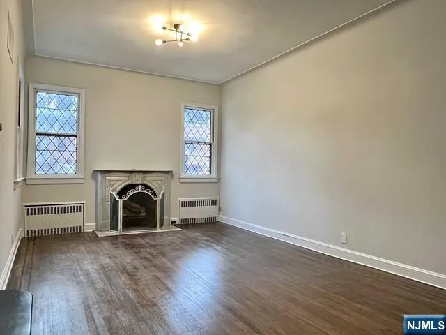 an entryway and a fireplace with wooden floor