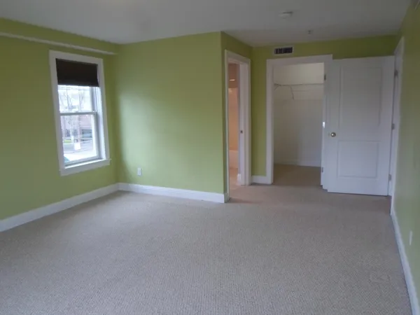 an empty room with windows and closet