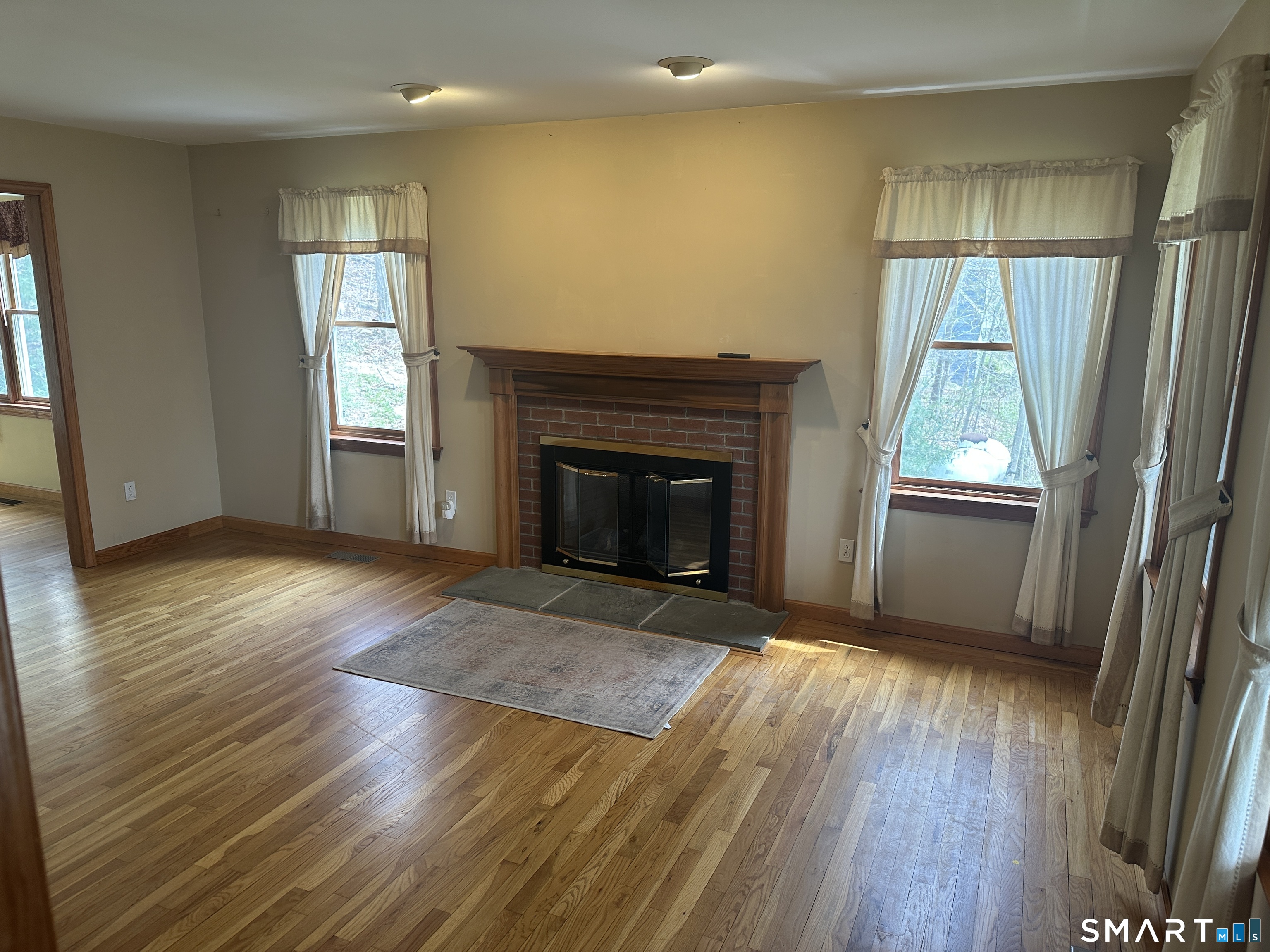 181 North Chestnut Hill Road Killingworth, CT 06419 - Photo 14 of 26 an empty room with wooden floor fireplace and windows