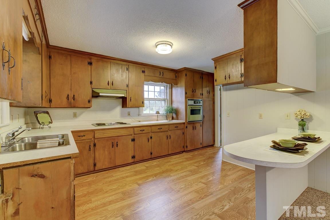 716 Sheriff Johnson Road Coats, NC 27521 - Photo 7 of 25 a kitchen with stainless steel appliances granite countertop a sink dishwasher stove refrigerator and cabinets with wooden floor