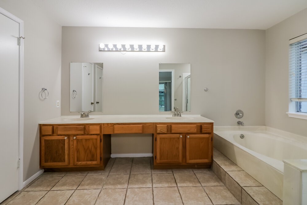 9423 Bayou Bluff Drive Spring, TX 77379 - Photo 11 of 16 a spacious bathroom with a sink a mirror and a bathtub