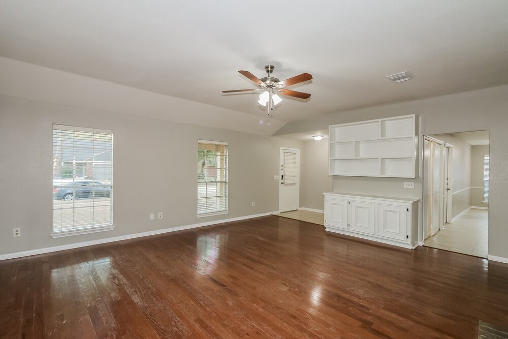 9423 Bayou Bluff Drive Spring, TX 77379 - Photo 4 of 16 a view of an empty room with a window and wooden floor