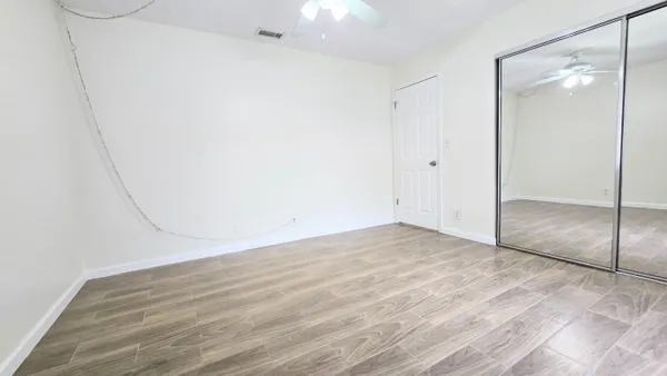 an empty room with wooden floor and windows