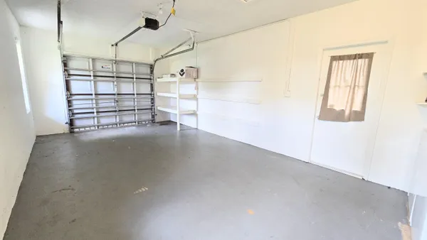 front view of a house with a yard and potted plants