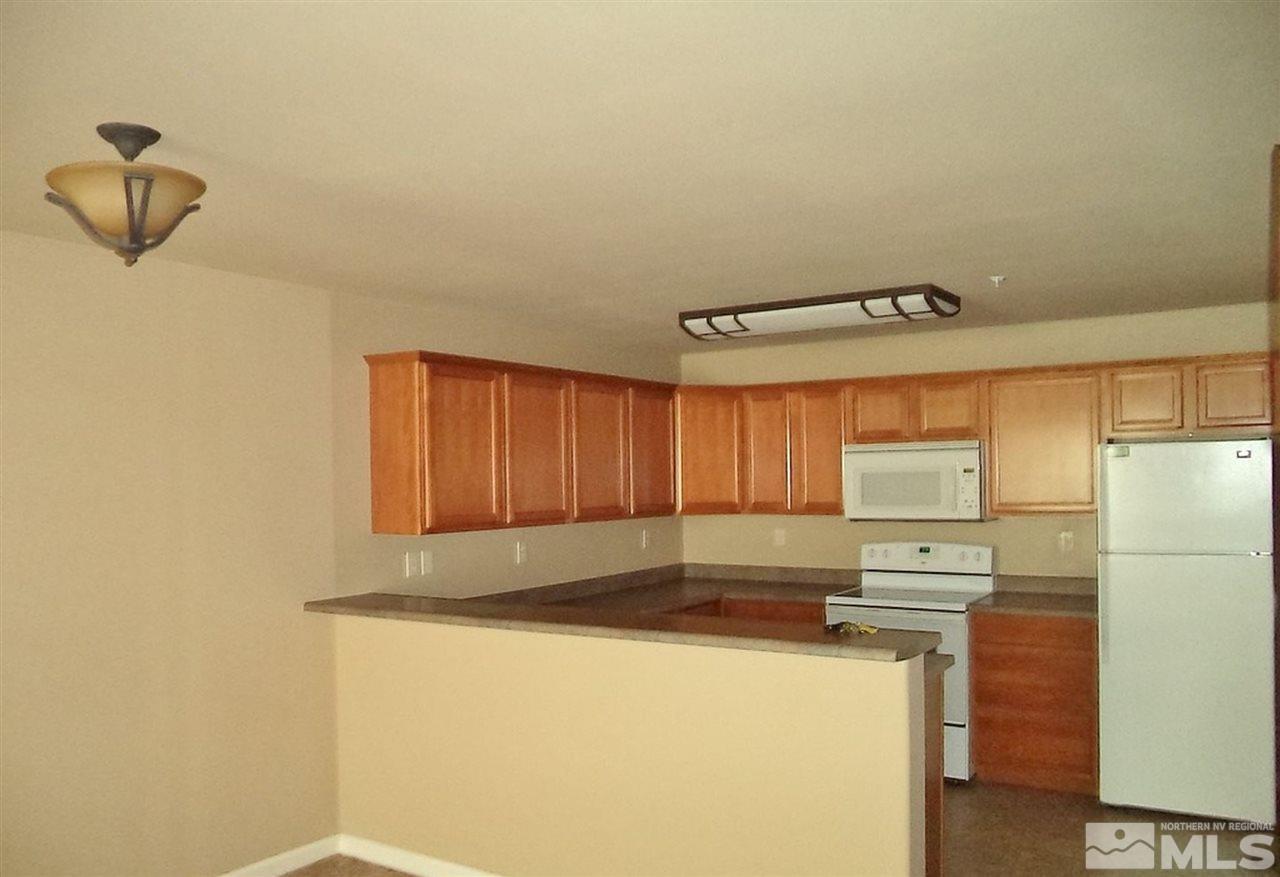 1052 Watt Street Reno, NV 89509 - Photo 25 of 25 a kitchen with a refrigerator a stove and a cabinets