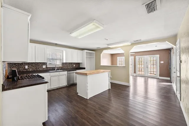 a large kitchen with granite countertop a sink and a stove top oven