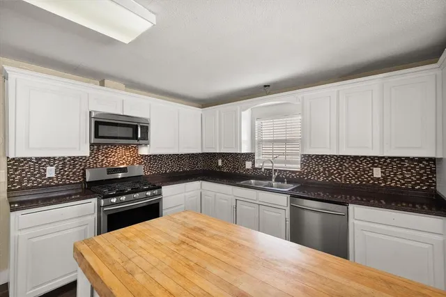 a kitchen with granite countertop white cabinets and appliances