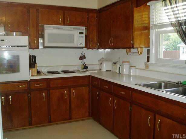 412 Roxanne Drive Raleigh, NC 27603 - Photo 4 of 8 a kitchen with stainless steel appliances granite countertop a sink stove and microwave