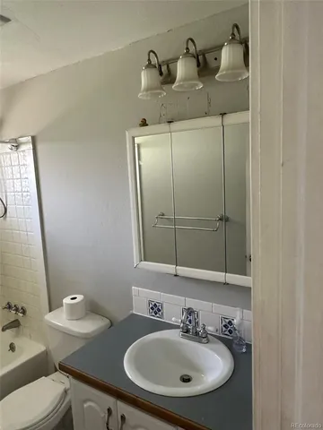 a bathroom with a sink toilet and mirror