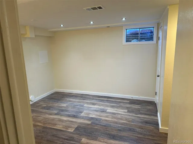 a view of empty room with wooden floor