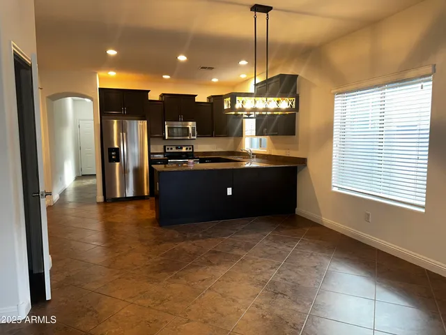 a open kitchen with stainless steel appliances granite countertop a refrigerator and a sink