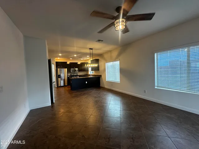 a view of a livingroom with furniture a ceiling fan and window