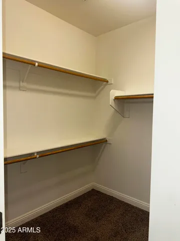 an empty room with windows and chandelier fan