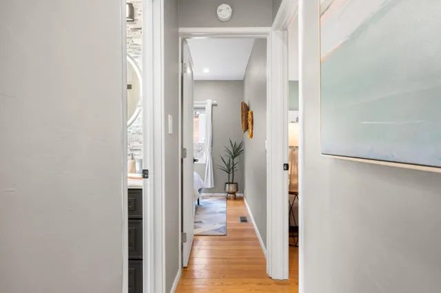 a view of a hallway with wooden floor and a living room