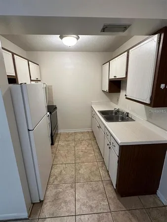 a kitchen with stainless steel appliances a stove a sink and a refrigerator