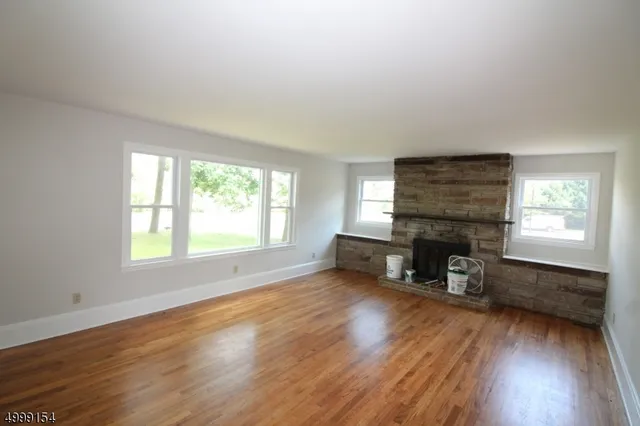 an empty room with furniture fireplace and wooden floor