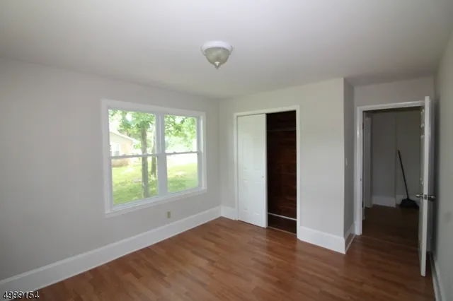 an empty room with wooden floor and a window