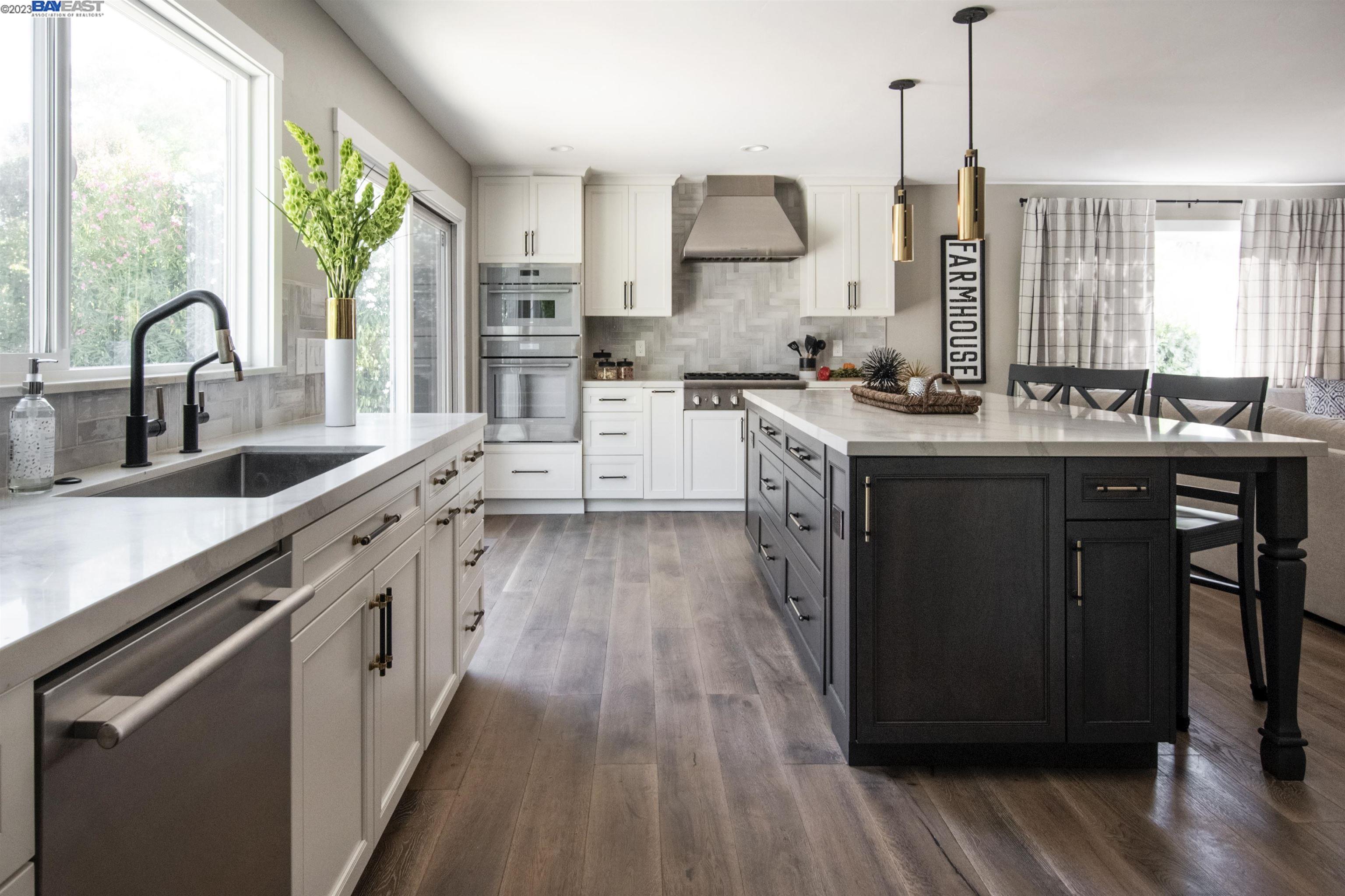 a kitchen with stainless steel appliances granite countertop a stove a sink dishwasher a refrigerator and wooden floor