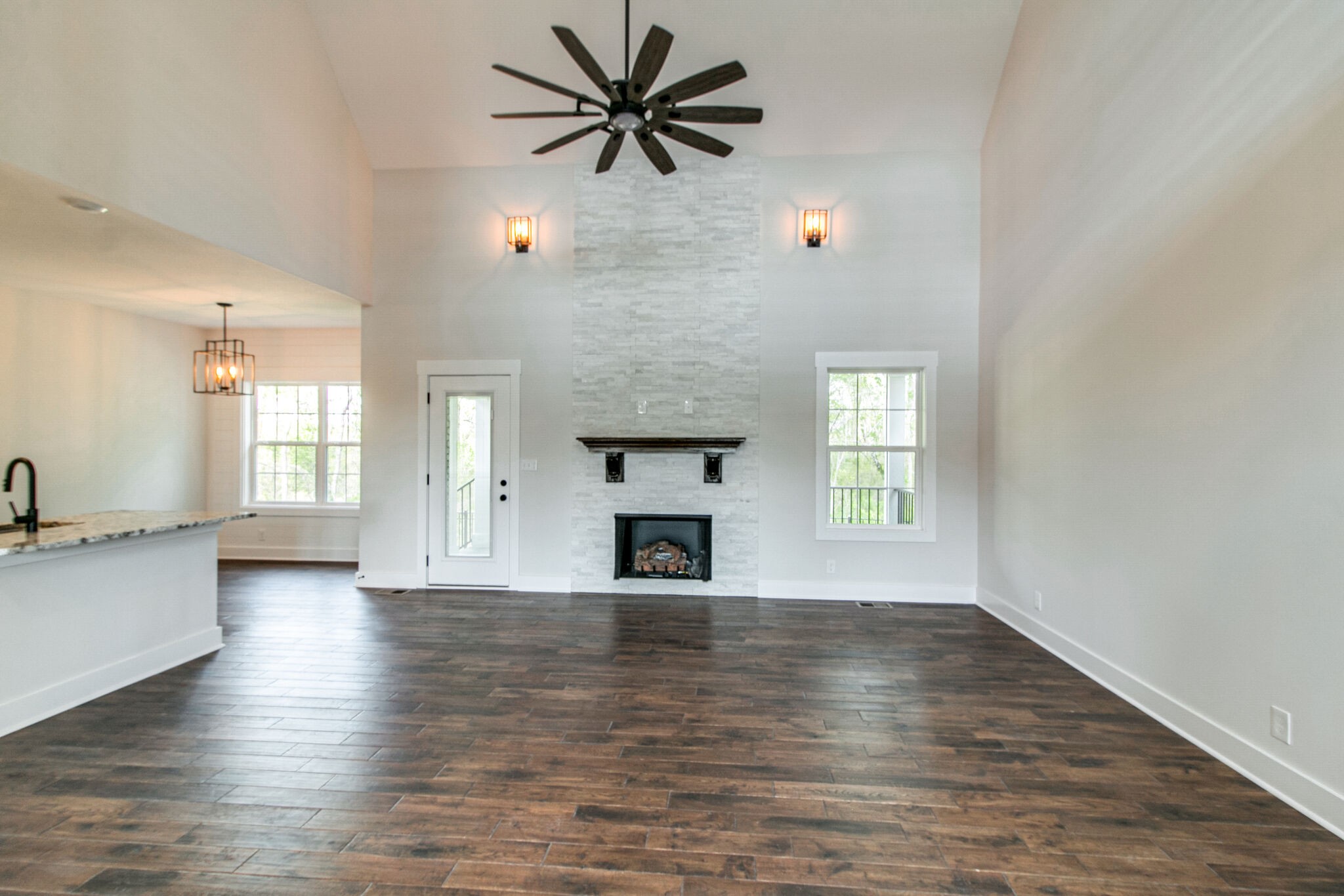 259 Harrowgate Drive Clarksville, TN 37043 - Photo 7 of 39 an empty room with wooden floor fireplace and windows