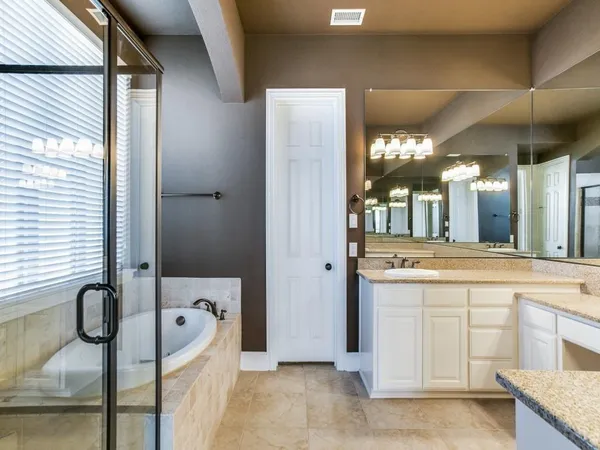 a bathroom with a tub sink and mirror