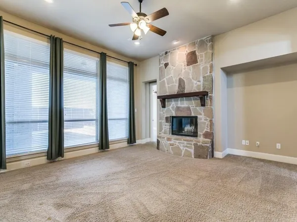 a view of an empty room with a fireplace and a window