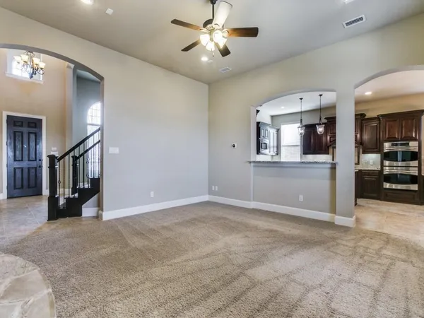 an empty room with closet and a chandelier fan