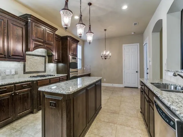 a kitchen with stainless steel appliances granite countertop stove a sink and a refrigerator
