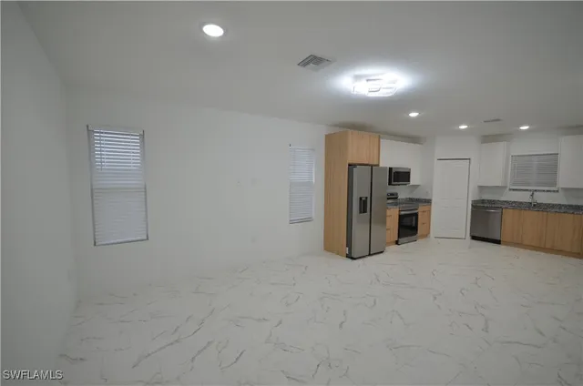 a view of a kitchen with refrigerator and a sink