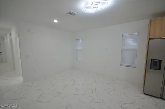 a large kitchen with stainless steel appliances granite countertop a refrigerator and a stove top oven