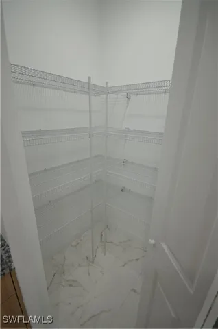 a kitchen with stainless steel appliances granite countertop a refrigerator a stove a microwave oven with white cabinets