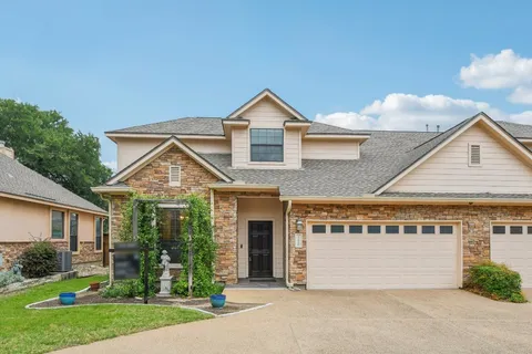 front view of a house with a yard and an trees