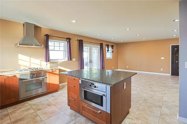 a kitchen with stainless steel appliances granite countertop a stove a sink and a refrigerator