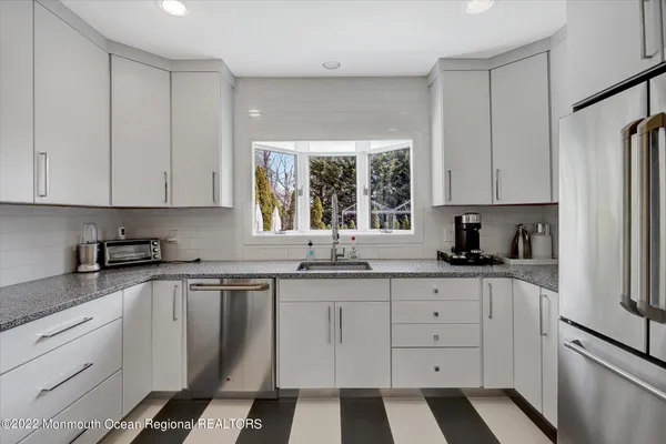 a kitchen with granite countertop white cabinets and white appliances