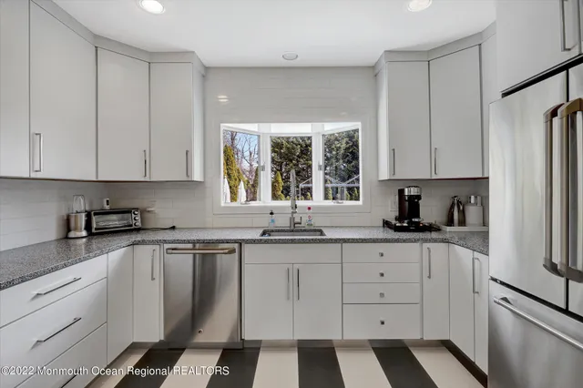 a kitchen with granite countertop white cabinets and white appliances